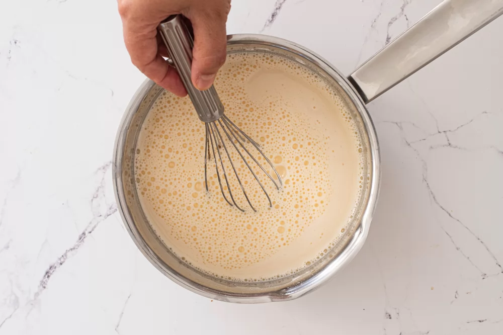Verter la leche y cocinar la crema hasta que espese
