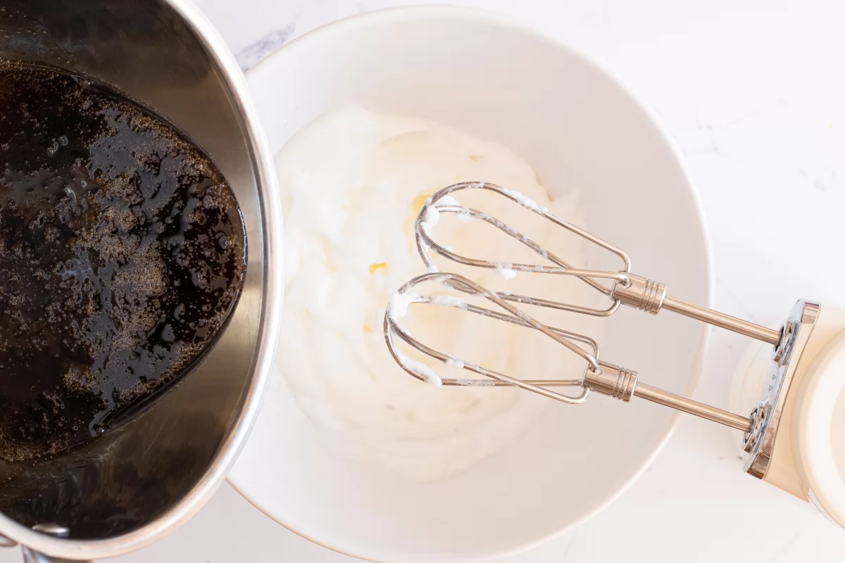 Verter el almíbar sobre las claras batidas para hacer el merengue